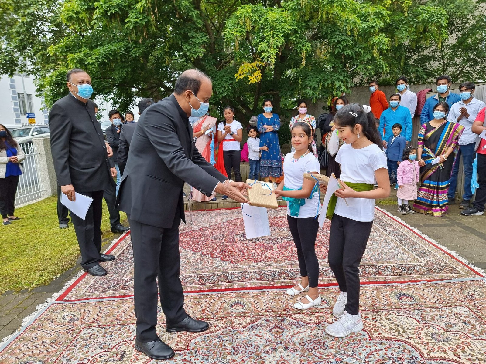 Children receiving gifts during an outdoor Indian national-day community celebration